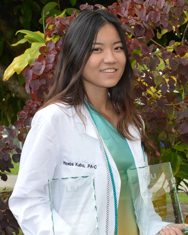 Phoebe Kubo in her white coat, holding her two awards